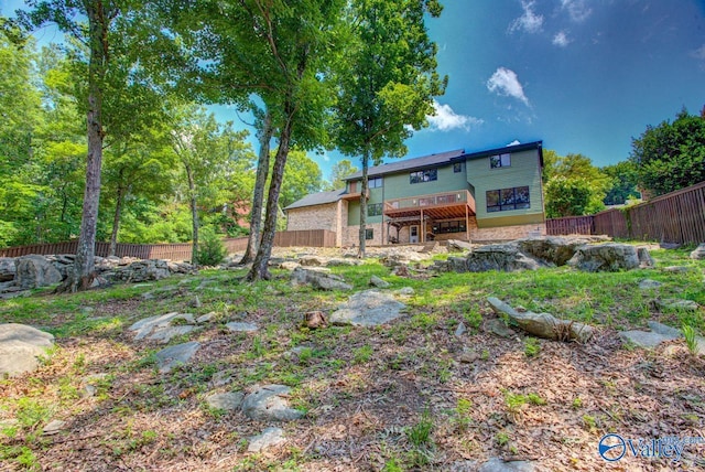 rear view of property featuring a wooden deck