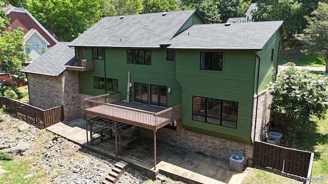 back of house with cooling unit, a deck, and a patio