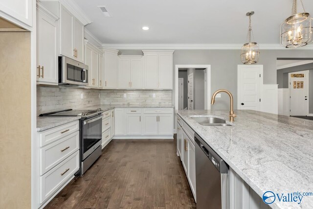 kitchen featuring dark hardwood / wood-style flooring, light stone counters, sink, pendant lighting, and appliances with stainless steel finishes