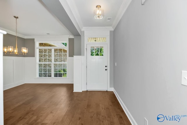 doorway to outside with dark wood-type flooring, a chandelier, and ornamental molding