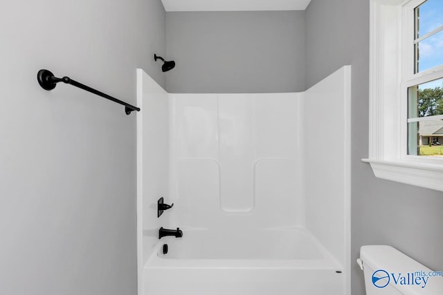 bathroom featuring shower / bathing tub combination and toilet