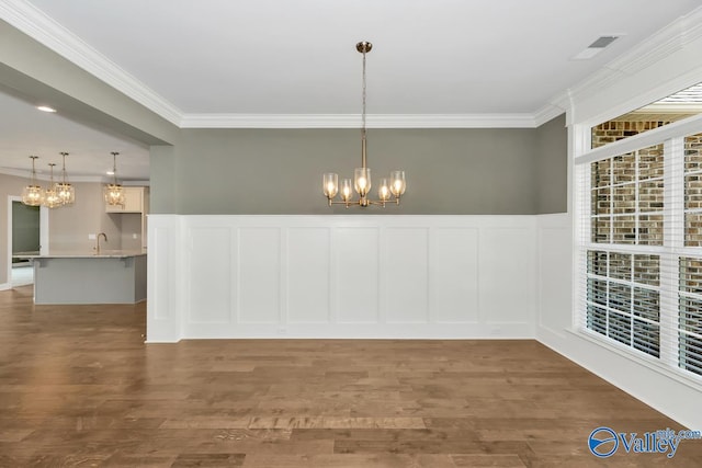 unfurnished dining area featuring ornamental molding, sink, and dark hardwood / wood-style floors