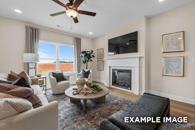 29555 Canoe Cir, Harvest, AL 35749 - living room featuring visible vents, baseboards, ceiling fan, wood finished floors, and a glass covered fireplace
