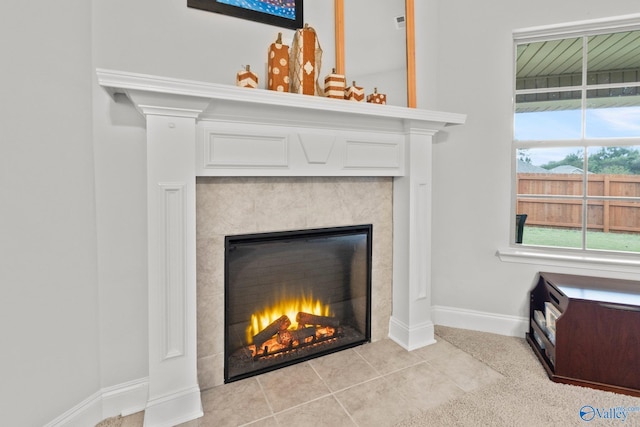 interior details with baseboards and a tiled fireplace