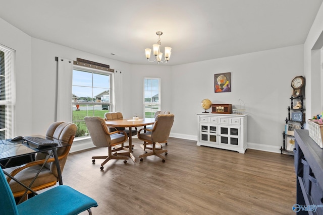 dining area featuring baseboards, an inviting chandelier, and wood finished floors