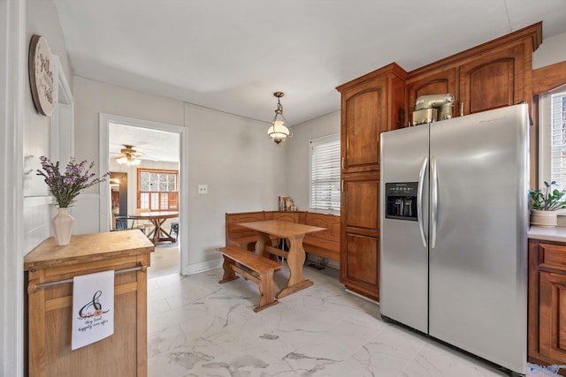 kitchen with stainless steel refrigerator with ice dispenser, plenty of natural light, and pendant lighting