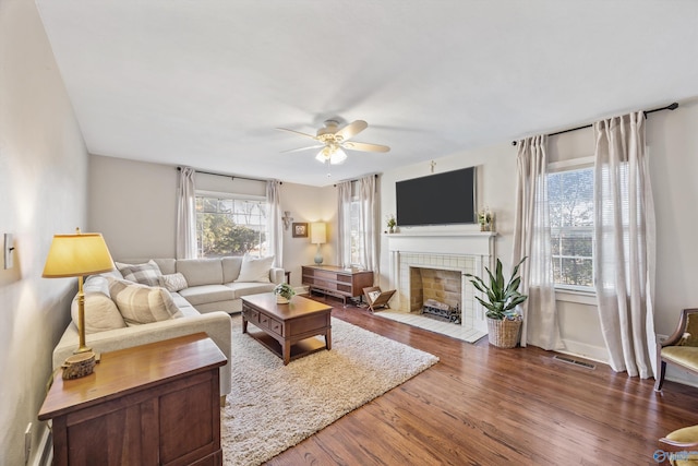 living room with ceiling fan, dark hardwood / wood-style floors, and a fireplace