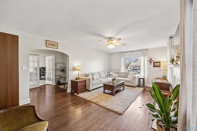 living room with dark wood-type flooring and ceiling fan