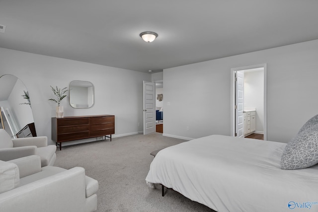 carpeted bedroom featuring baseboards, visible vents, and connected bathroom
