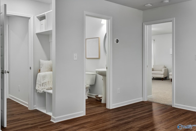 bedroom featuring baseboards, connected bathroom, and wood finished floors