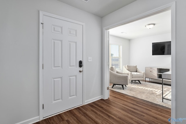 foyer entrance with baseboards and dark wood-type flooring