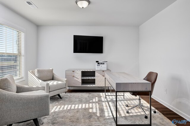 office area with baseboards, visible vents, and wood finished floors
