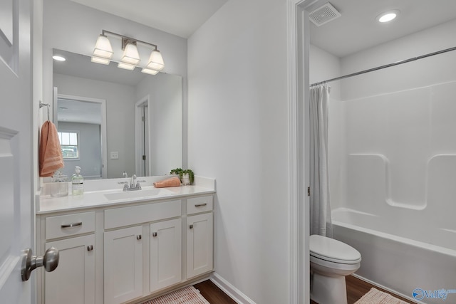 bathroom with vanity, visible vents, wood finished floors, toilet, and shower / bathtub combination with curtain
