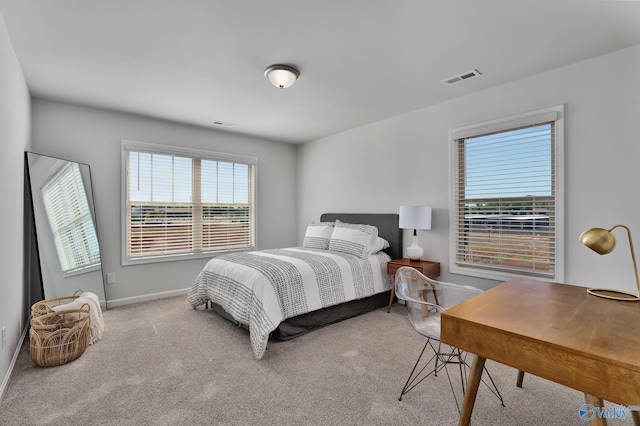 carpeted bedroom featuring baseboards, visible vents, and multiple windows