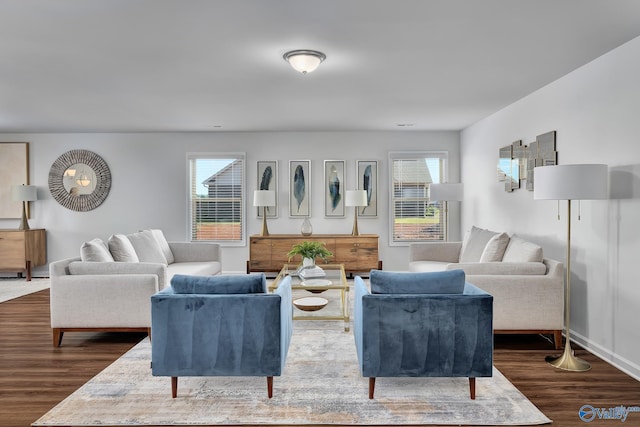 living area featuring a healthy amount of sunlight, baseboards, and dark wood finished floors
