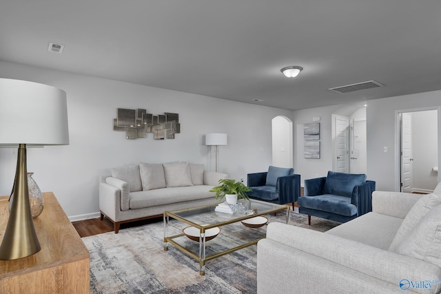 living room featuring baseboards, visible vents, and wood finished floors