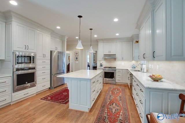 kitchen featuring decorative light fixtures, white cabinets, a center island, and high quality appliances