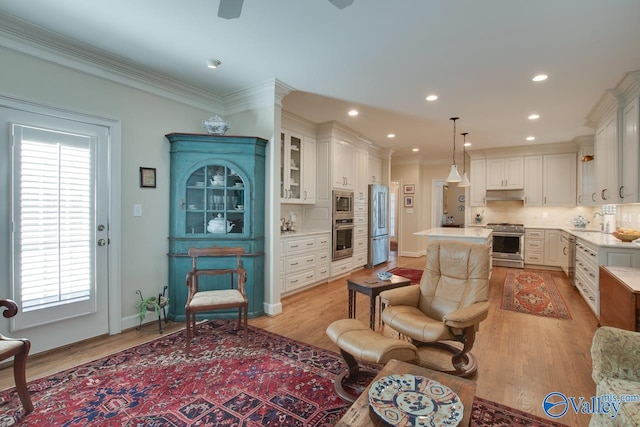 kitchen featuring white cabinetry, appliances with stainless steel finishes, decorative backsplash, hanging light fixtures, and a center island