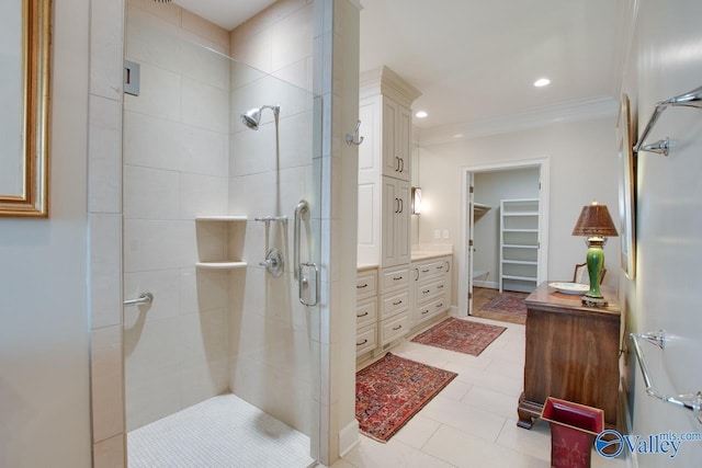 bathroom with vanity, tile patterned floors, a shower with door, and crown molding