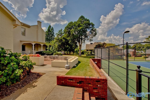 view of home's community with tennis court and a patio