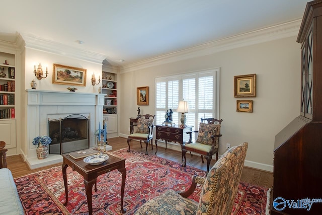 living room with wood-type flooring, built in shelves, and ornamental molding