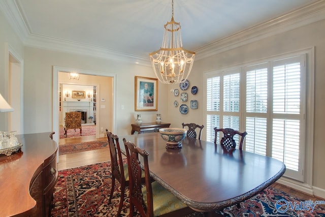 dining area with wood-type flooring, crown molding, and a chandelier