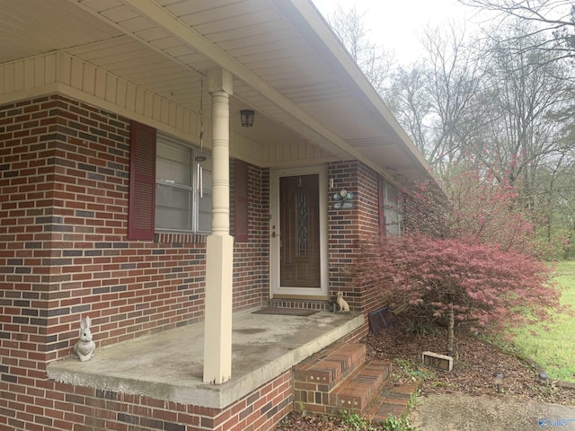 view of exterior entry featuring brick siding