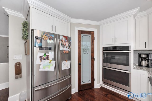 kitchen featuring dark wood-style flooring, white cabinets, stainless steel appliances, and baseboards