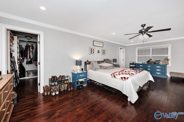 bedroom with recessed lighting, crown molding, wood-type flooring, and a walk in closet