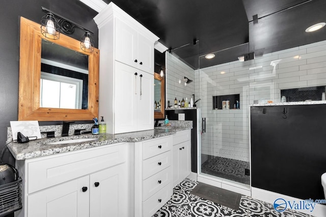 full bathroom featuring a stall shower, tile patterned flooring, and vanity