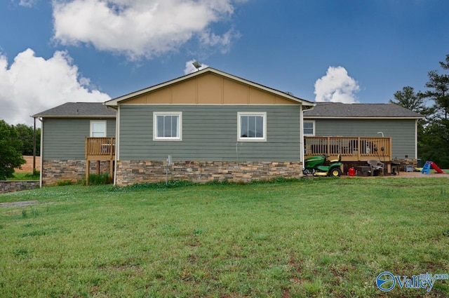 back of house featuring a wooden deck, a yard, and board and batten siding