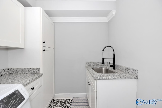 washroom featuring light tile patterned floors, cabinet space, a sink, baseboards, and crown molding