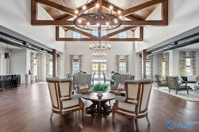 living room featuring ornate columns, a stone fireplace, dark hardwood / wood-style floors, and ornamental molding