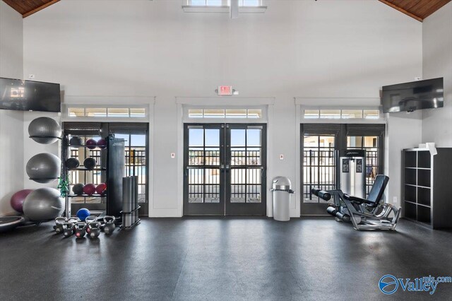 gym featuring wooden ceiling, a towering ceiling, and french doors