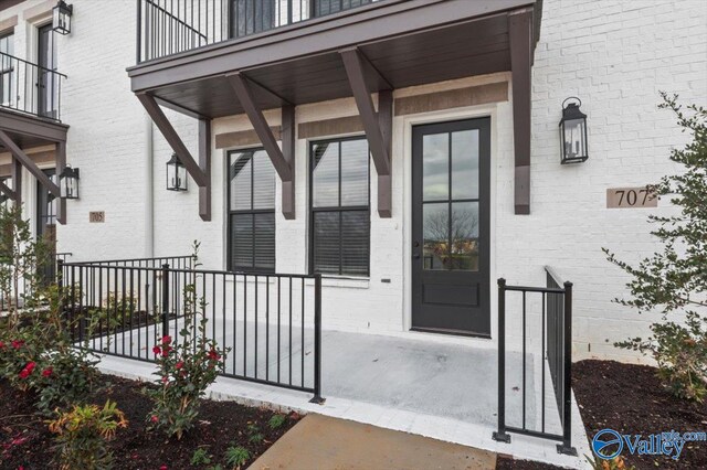 doorway to property featuring a porch and a balcony