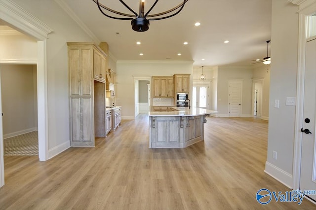 kitchen featuring a kitchen island with sink, backsplash, ornamental molding, and light wood-type flooring