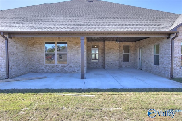 rear view of property featuring a lawn, ceiling fan, and a patio area