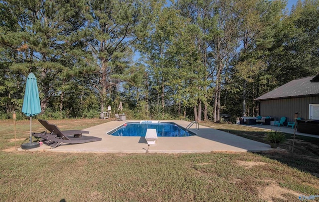 view of swimming pool featuring a lawn, a diving board, and a patio