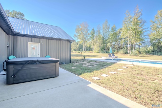 exterior space featuring a swimming pool with hot tub and a patio