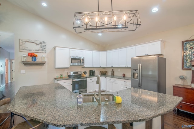 kitchen featuring white cabinetry, dark hardwood / wood-style flooring, dark stone countertops, vaulted ceiling, and appliances with stainless steel finishes