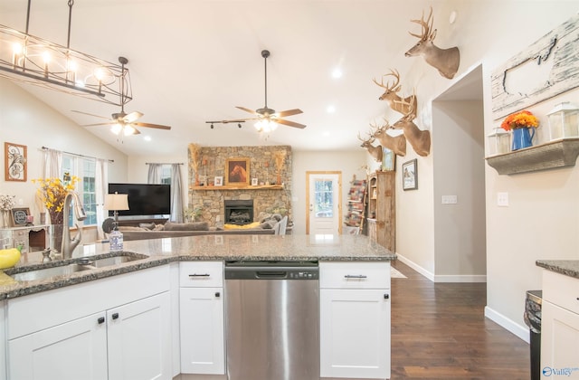 kitchen with stone counters, dishwasher, white cabinets, and sink