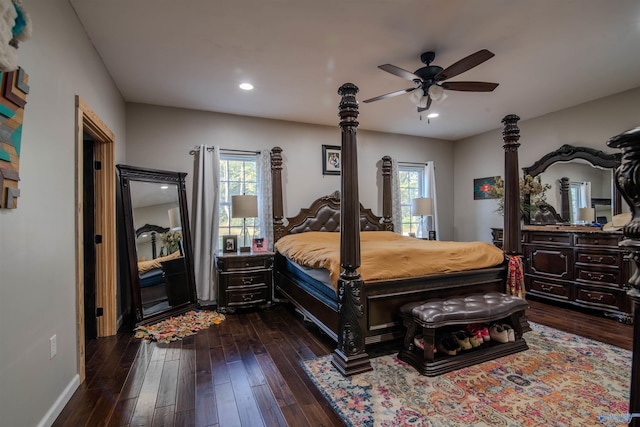 bedroom with ceiling fan, dark wood-type flooring, and multiple windows