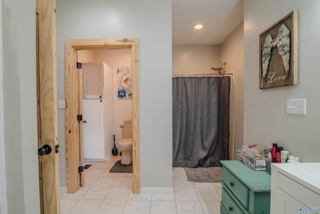 bathroom featuring tile patterned flooring, vanity, and toilet