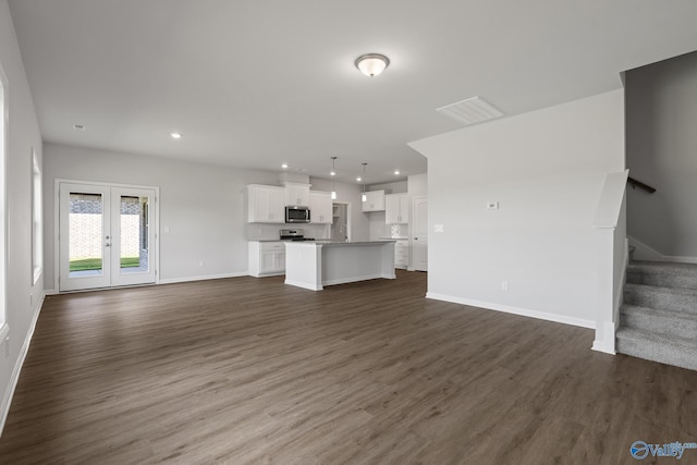 unfurnished living room with dark wood-type flooring, recessed lighting, stairway, french doors, and baseboards