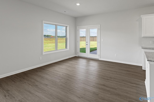 unfurnished living room with dark wood-style flooring, baseboards, recessed lighting, french doors, and visible vents
