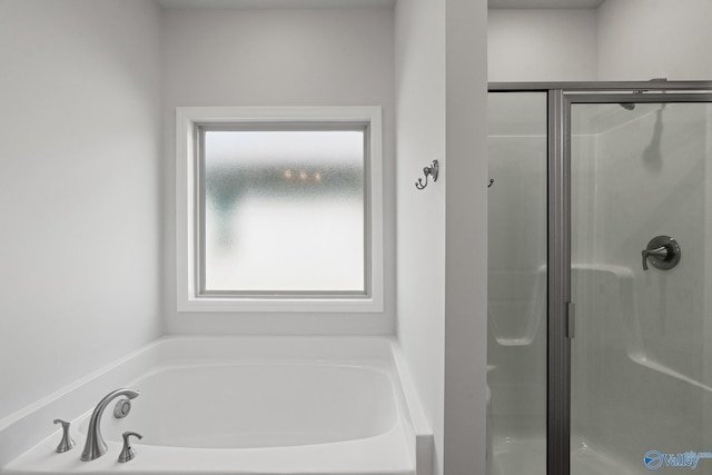 bathroom with a shower stall and a garden tub