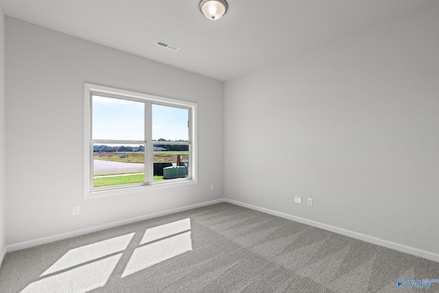 carpeted empty room with visible vents and baseboards