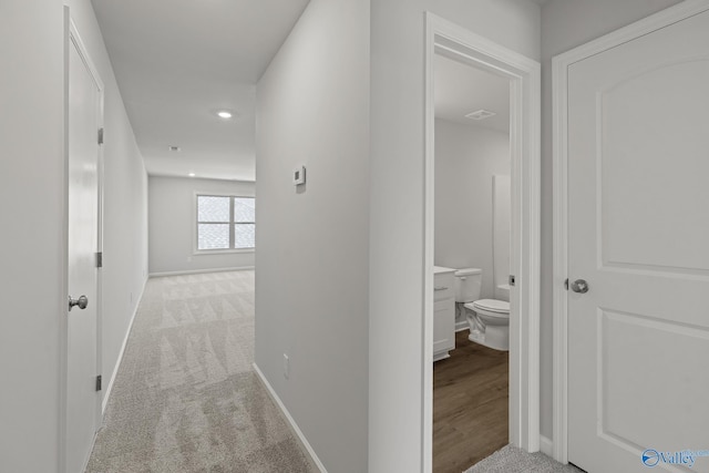 corridor with light colored carpet, baseboards, visible vents, and recessed lighting