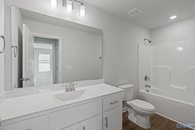 bathroom with tub / shower combination, vanity, visible vents, toilet, and wood finished floors