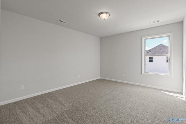 empty room with visible vents, baseboards, and carpet flooring